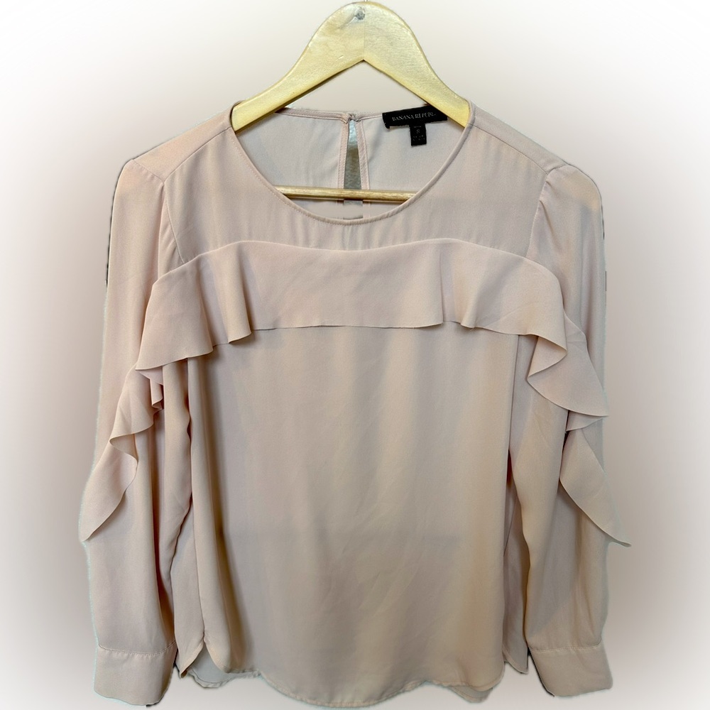 Blush pink blouse with ruffles down the sleeve.